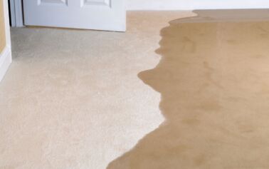 flooding water spreads quickly into a living room and causing water damage.